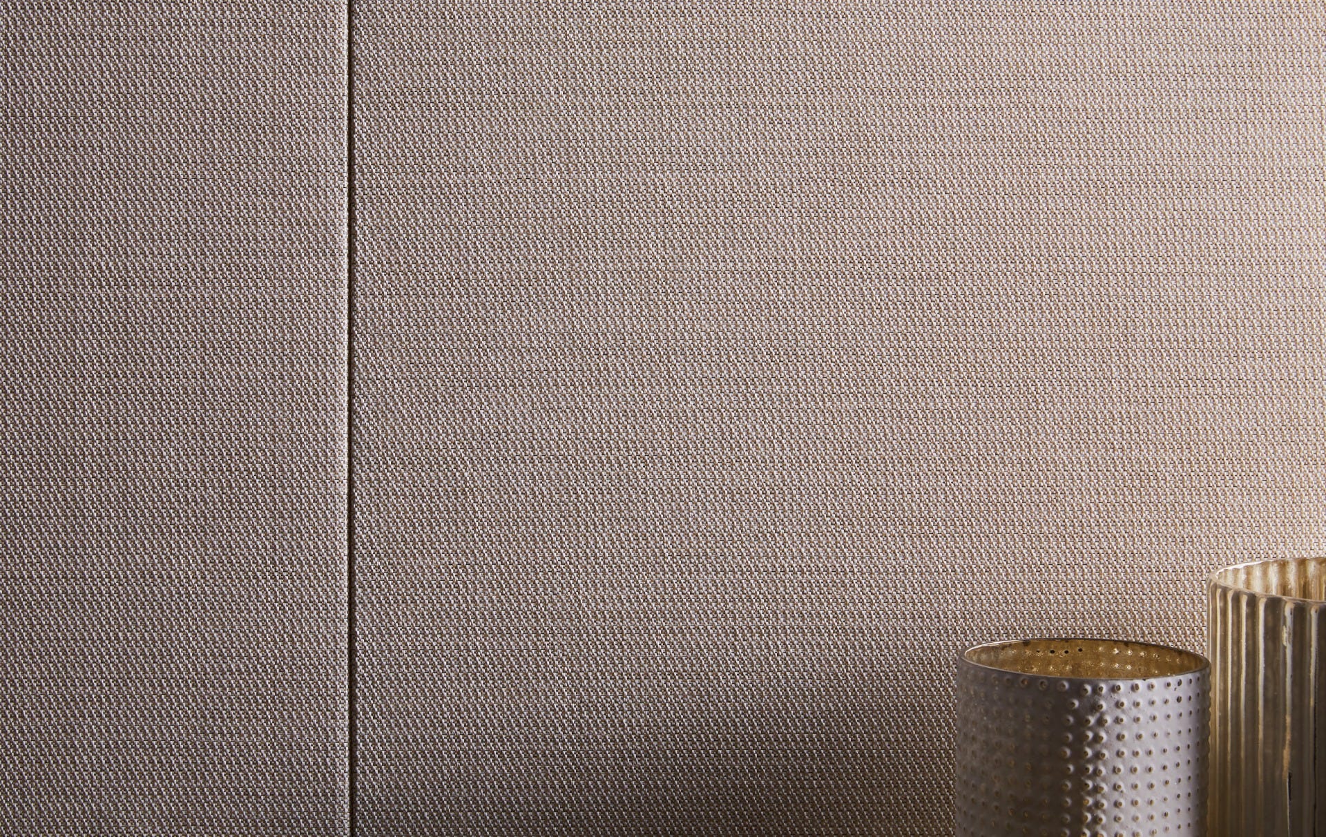 Finely woven Xorel wrapped wall panels beside a metal side table